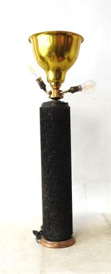 a black and gold lamp with a gold cup on top of it