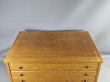 a small wooden chest of drawers on a white background