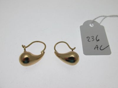 deux paires de boucles d'oreilles en or avec une étiquette sur un fond blanc