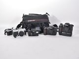 many cameras that are sitting on a white surface