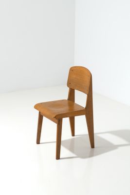 a small wooden chair sitting in a white room