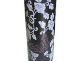 a black vase with white flowers on it on a white background