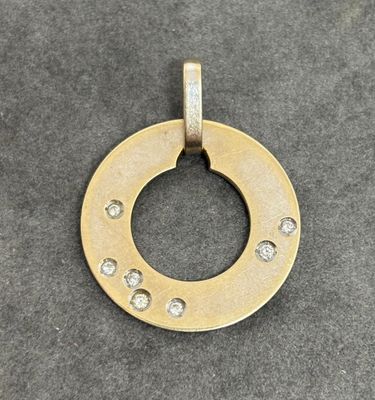 a close up of a gold plated pendant with diamonds on it