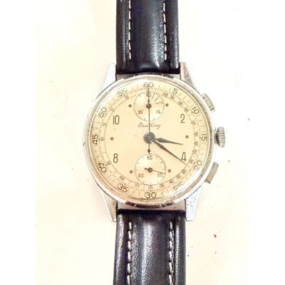une montre posée sur un bracelet en cuir noir