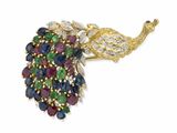 une image représentant une broche en forme de paon ornée de pierres multicolores