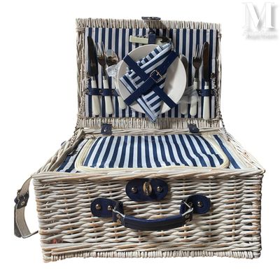 un panier de pique-nique en osier contenant une assiette, une fourchette et un couteau