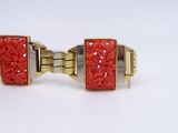 pair of red and gold tone cuff bracelets with floral design