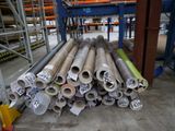 de nombreux rouleaux de métal posés à même le sol dans un entrepôt