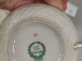 a person holding a cup and saucer on a table
