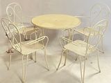 four chairs and a table in a room with a white wall