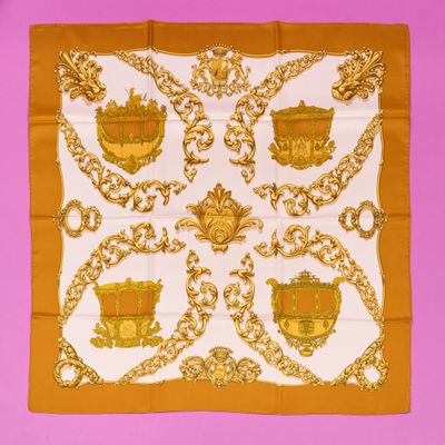 an orange and white scarf with a gold design on it