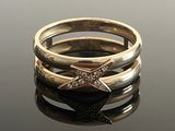 three gold rings with diamonds on a black surface