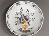 a small bowl with a vase of flowers on it