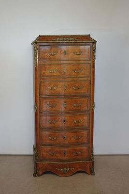 an antique chest of drawers in a room with a white wall