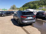 many cars parked in a parking lot with mountains in the background