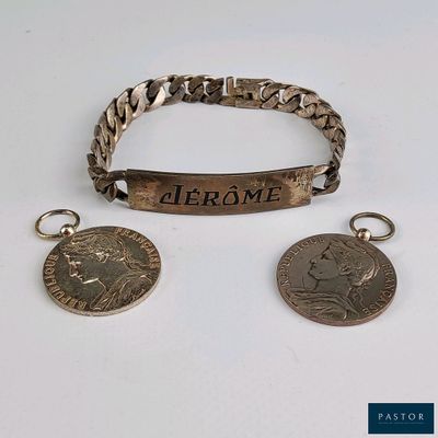 deux bracelets en argent et une pièce de monnaie sur laquelle est gravé un nom