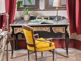 une chaise jaune placée devant un bureau sur lequel se trouve une lampe