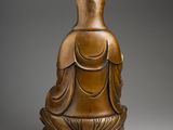 a bronze statue of a person sitting in a lotus position