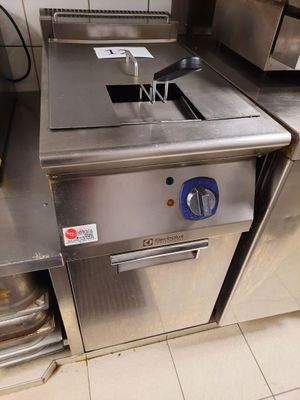plan de travail en acier inoxydable dans une cuisine professionnelle, avec une friteuse sur le côté
