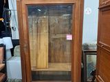 un meuble en bois avec une porte en verre au milieu d'une pièce