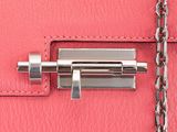 a close up of a pink purse with a chain around it