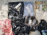 de nombreux vêtements de toutes sortes, rangés dans des sacs en plastique posés sur une table