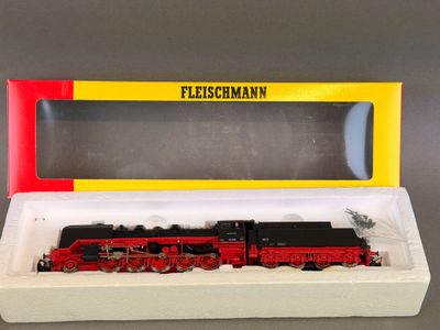 un train rouge et noir dans une boîte posée sur une table