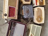 many old radio ' s that are sitting on the floor
