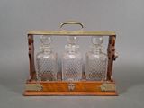 an image of a wooden and glass decanter with three bottles