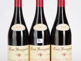 trois bouteilles de vin rouge posées l'une à côté de l'autre sur une surface blanche