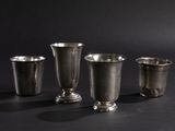 three silver cups sitting next to each other on a black surface