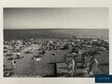 black and white photograph of a crowded beach with people on it
