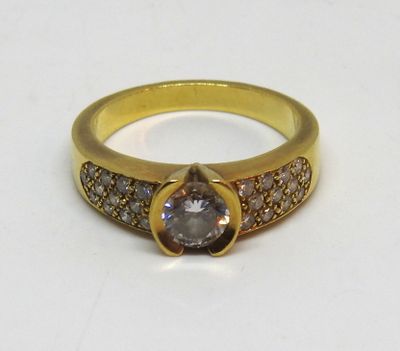 un gros plan sur une bague en or sertie d'un diamant brun et blanc