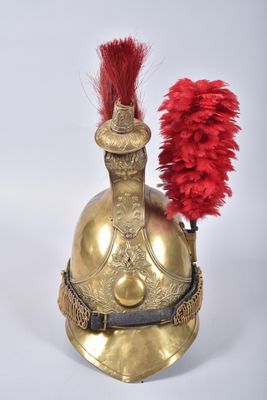 gold helmet with red feathers on top of it on a white surface