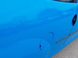 a blue car that has a hole in the side of it