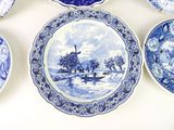 many blue and white plates on a white table