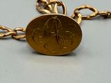 an image of a gold chain bracelet with a coin on it