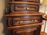 a tall wooden cabinet with a clock on top of it