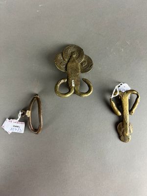 trois morceaux de métal sont posés sur une table à côté d'une paire de ciseaux et d'une paire de ciseaux