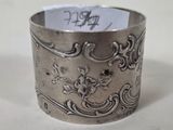a silver ring on a table with a note in it