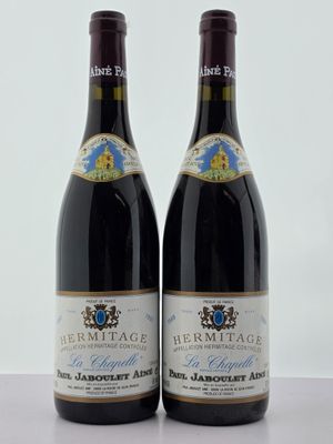 deux bouteilles de vin posées sur une table l'une à côté de l'autre