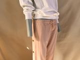 une photo d'un mannequin portant une chemise blanche et un pantalon rose