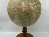 an old globe on a wooden stand with a white background