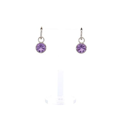 une paire de boucles d'oreilles ornées de pierres violettes sur fond blanc