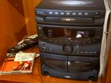 a stack of dvd players sitting on top of a wooden shelf