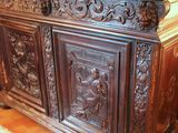 a wooden cabinet with carvings on it in a room