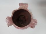 a pink vase that is sitting on a white table