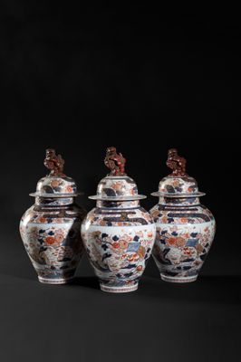 three chinese vases with lids are sitting on a black surface
