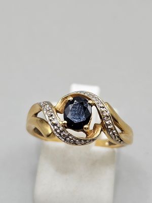 a close up of a gold ring with a blue sapphire and diamonds
