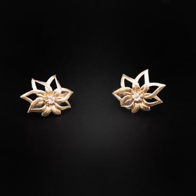 une paire de boucles d'oreilles en forme de fleurs dorées sur fond noir